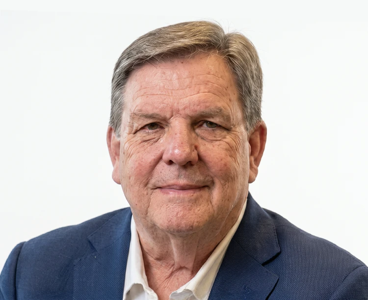 Portrait of a mature man in a blue blazer posing against a plain white background.